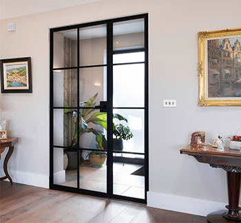 Crittall style single steel door with a sidelight in traditional room setting
